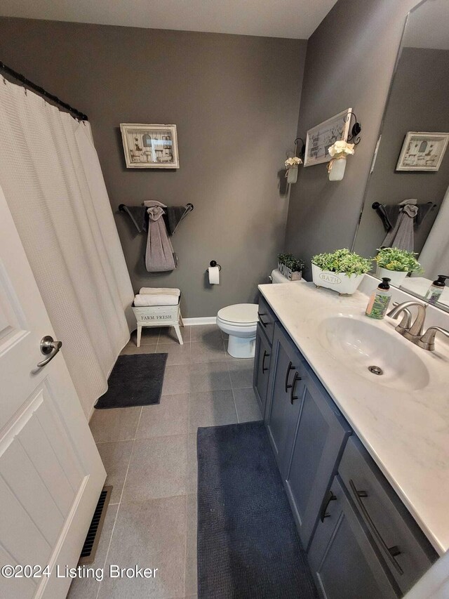 bathroom featuring tile patterned flooring, vanity, and toilet