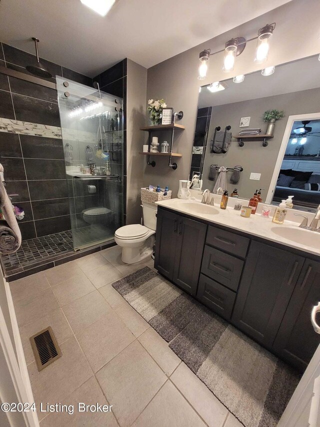 bathroom featuring a shower with door, toilet, and vanity