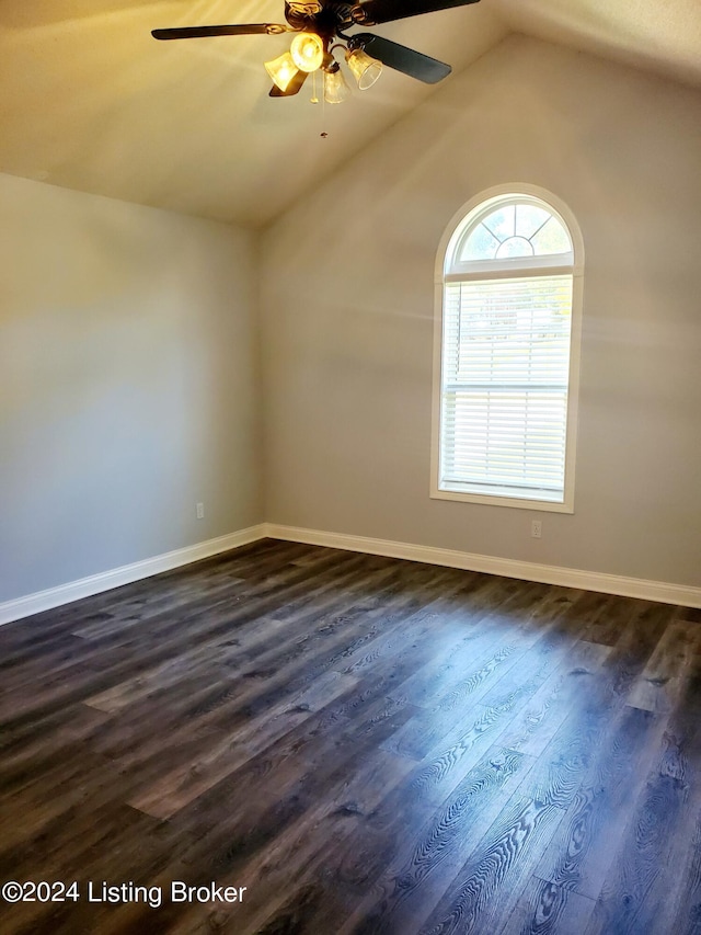 spare room with lofted ceiling, ceiling fan, dark wood finished floors, and baseboards