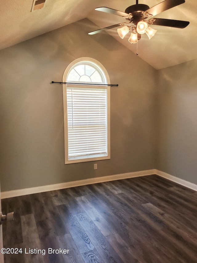 unfurnished room featuring visible vents, baseboards, a ceiling fan, dark wood-type flooring, and vaulted ceiling