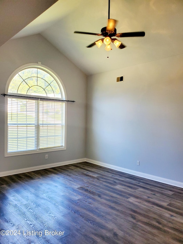 unfurnished room featuring baseboards, visible vents, vaulted ceiling, and dark wood-type flooring