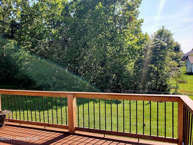 wooden terrace featuring a lawn