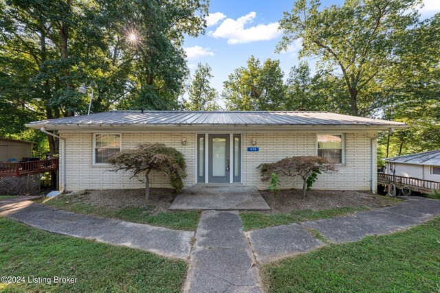 view of front of house with a patio area, a deck, and a front yard