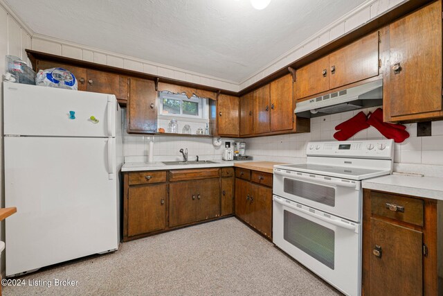 kitchen featuring white appliances, tasteful backsplash, and sink