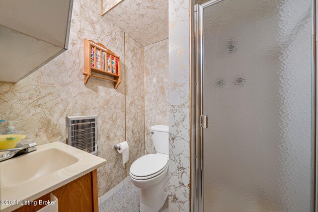 bathroom with vanity, toilet, tile walls, and a shower with shower door