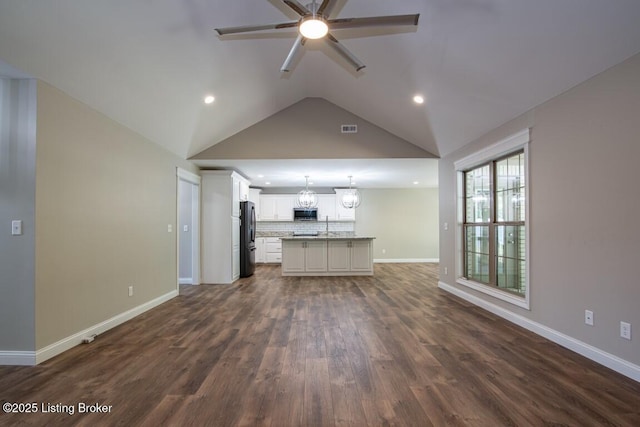 unfurnished living room with lofted ceiling, sink, ceiling fan with notable chandelier, and dark hardwood / wood-style flooring