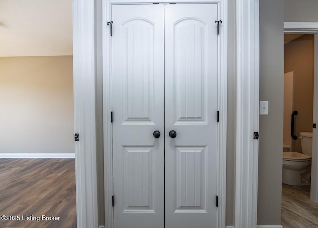 interior details with toilet and hardwood / wood-style floors