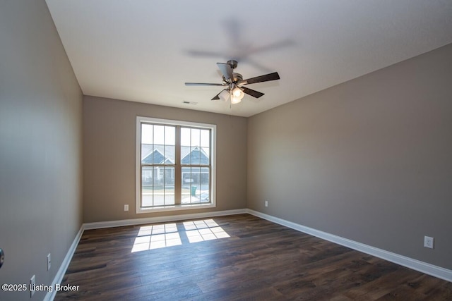 spare room with dark wood-type flooring and ceiling fan