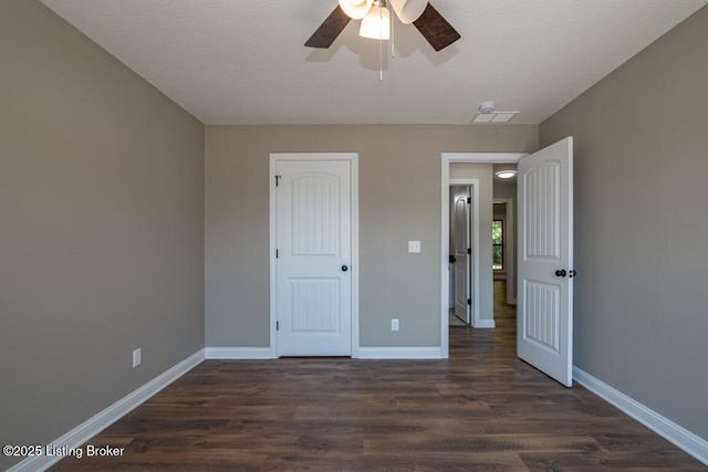 unfurnished bedroom with dark hardwood / wood-style flooring and ceiling fan