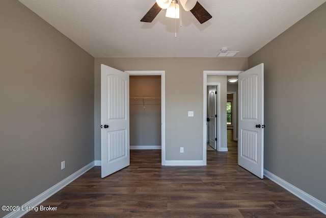 unfurnished bedroom featuring ceiling fan, dark hardwood / wood-style flooring, and a closet