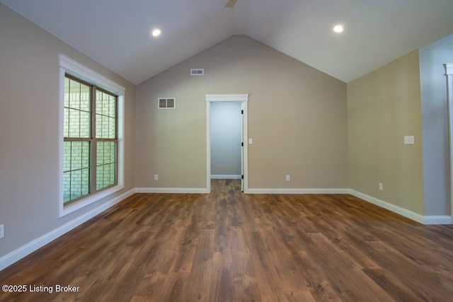 empty room with dark hardwood / wood-style flooring and vaulted ceiling