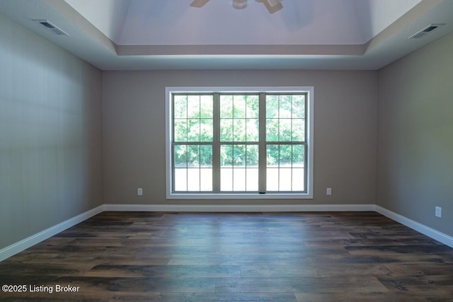 unfurnished room with dark hardwood / wood-style floors, ceiling fan, and a tray ceiling