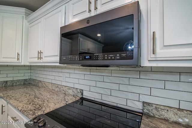 details with white cabinetry, decorative backsplash, and range