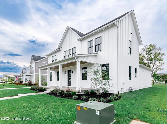 modern farmhouse style home featuring a front yard and covered porch