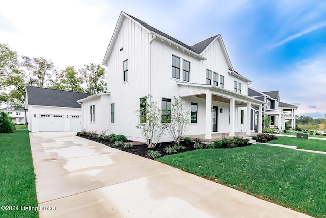 modern farmhouse featuring a porch, a garage, and a front yard