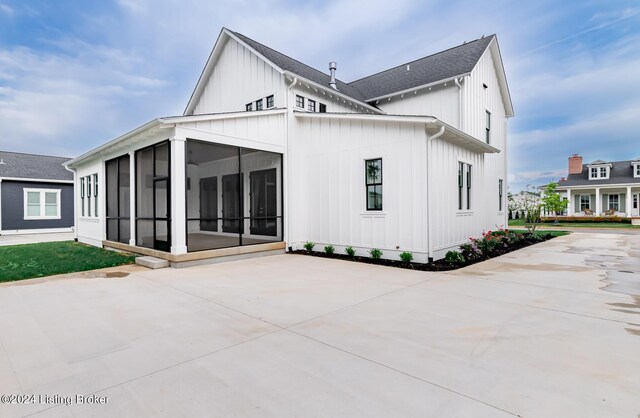 rear view of house featuring a sunroom