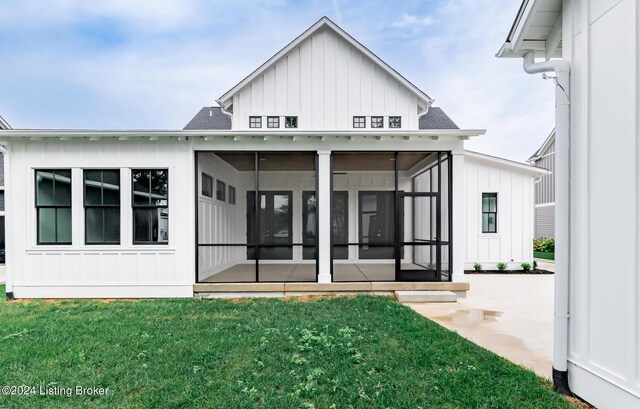 rear view of property with a yard and a sunroom