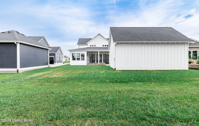 back of house with a lawn and a sunroom