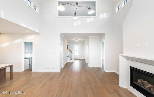 corridor with a towering ceiling and hardwood / wood-style floors