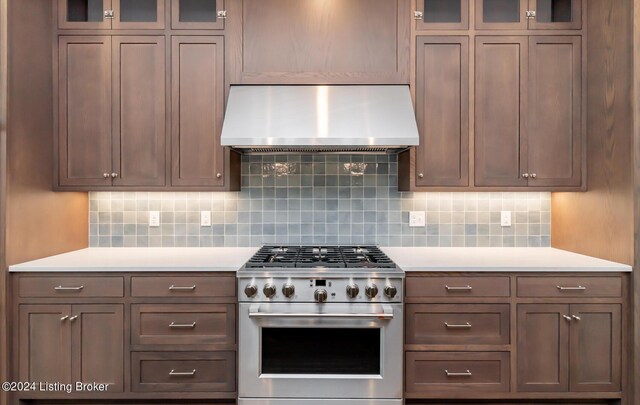 kitchen featuring high end stainless steel range, backsplash, and wall chimney range hood