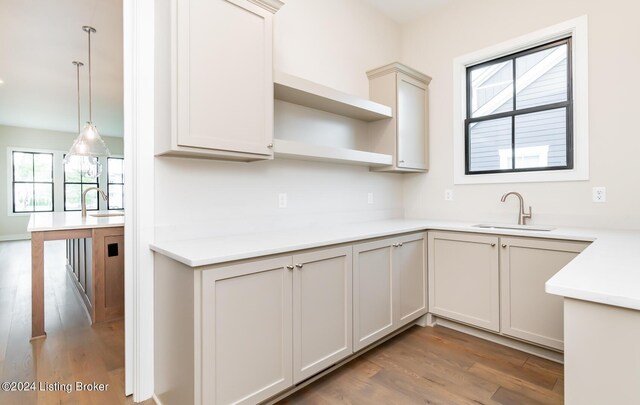 kitchen featuring pendant lighting, sink, and wood-type flooring