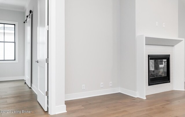 unfurnished living room featuring a barn door and wood-type flooring