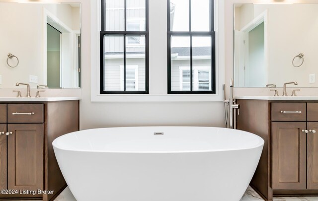 bathroom with vanity and a bath