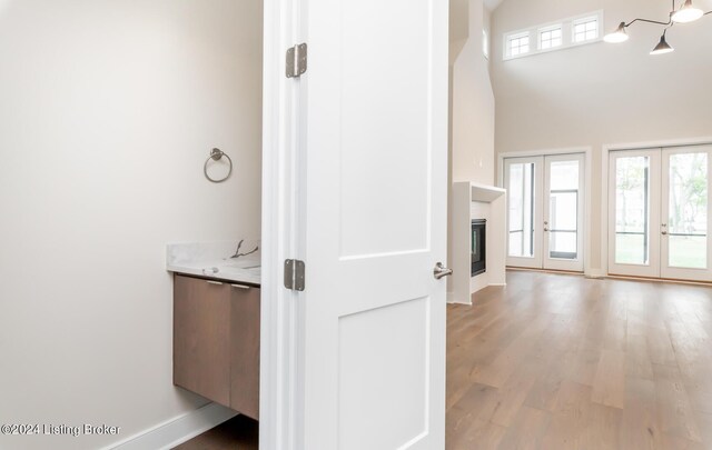 bathroom featuring a high ceiling, hardwood / wood-style floors, and french doors