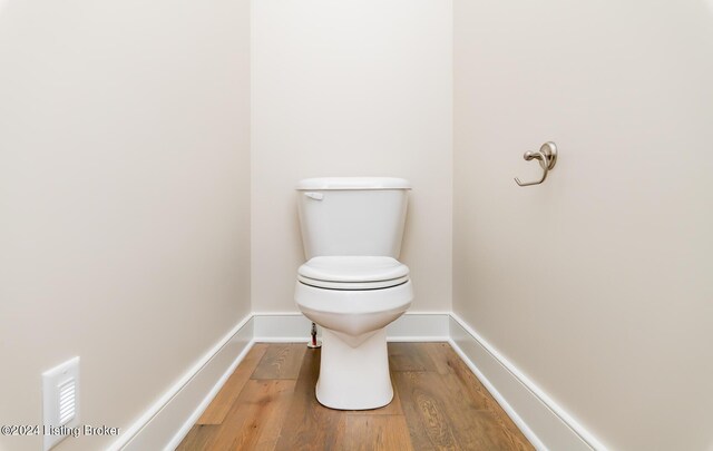 bathroom featuring hardwood / wood-style flooring and toilet