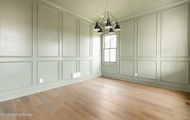 unfurnished dining area featuring light wood-type flooring and a chandelier