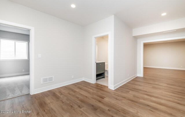 interior space with ensuite bathroom and light hardwood / wood-style flooring