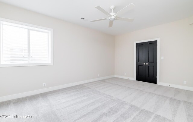 carpeted spare room featuring ceiling fan