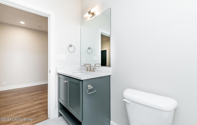 bathroom featuring vanity, toilet, and hardwood / wood-style flooring