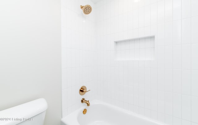 bathroom with tiled shower / bath and toilet