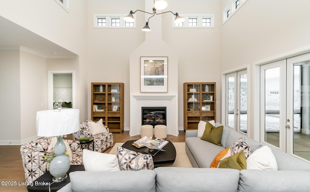 living room featuring hardwood / wood-style flooring, a towering ceiling, and plenty of natural light