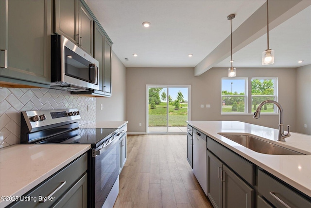 120 Exploration Path Unit 5B, Shelbyville, KY 40065 - kitchen with stainless steel appliances, a sink, light wood-style flooring, decorative backsplash, and light countertops