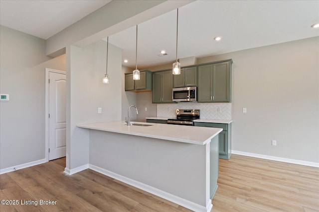 120 Exploration Path Unit 5B, Shelbyville, KY 40065 - kitchen with a sink, stainless steel appliances, light wood-type flooring, backsplash, and light countertops
