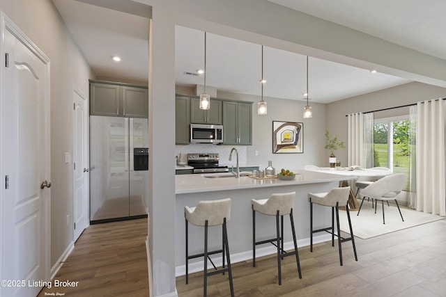 120 Exploration Path Unit 5B, Shelbyville, KY 40065 - kitchen with stainless steel appliances, a kitchen breakfast bar, wood finished floors, decorative backsplash, and a sink