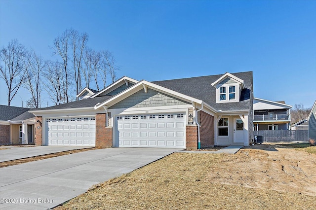 view of front of property with brick siding, concrete driveway, fence, a garage, and cooling unit