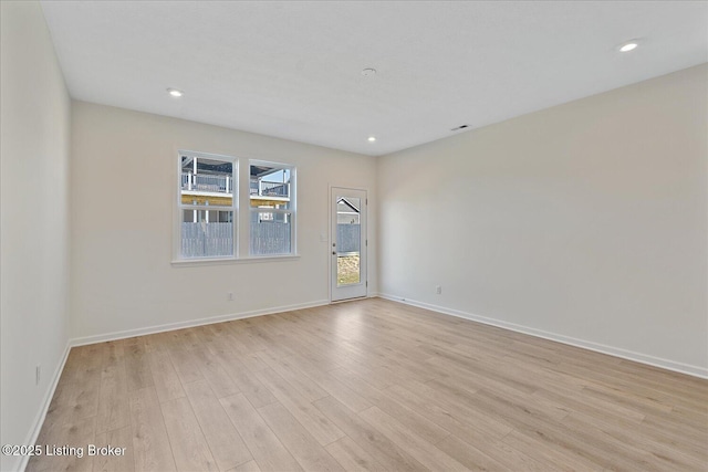 spare room featuring baseboards, light wood finished floors, and recessed lighting