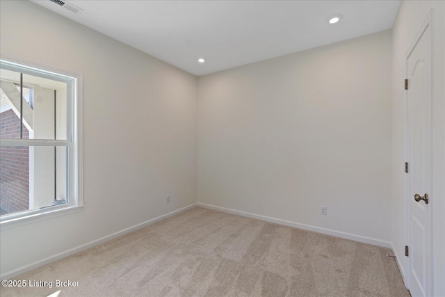 carpeted spare room featuring baseboards, visible vents, and recessed lighting