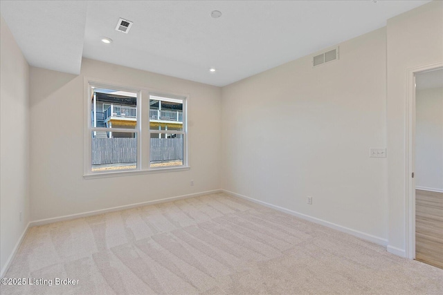 carpeted spare room featuring recessed lighting, visible vents, and baseboards