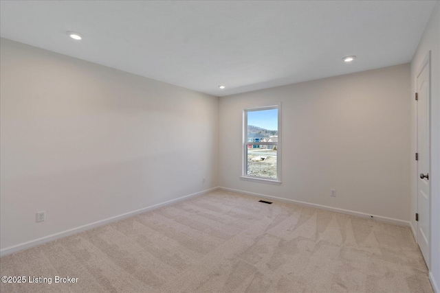 unfurnished room with visible vents, recessed lighting, light colored carpet, and baseboards