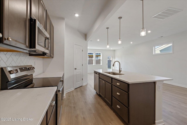 188 Harvest Moon Ct Unit 219B, Shepherdsville, KY 40165 - kitchen with appliances with stainless steel finishes, a sink, dark brown cabinets, light wood finished floors, and decorative backsplash