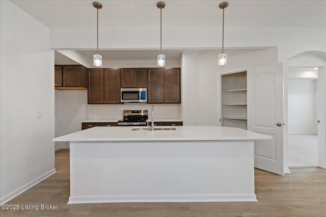188 Harvest Moon Ct Unit 219B, Shepherdsville, KY 40165 - kitchen with appliances with stainless steel finishes, arched walkways, a sink, tasteful backsplash, and dark brown cabinetry