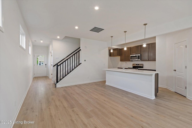 188 Harvest Moon Ct Unit 219B, Shepherdsville, KY 40165 - kitchen with stainless steel appliances, dark brown cabinetry, a sink, light wood-type flooring, and backsplash