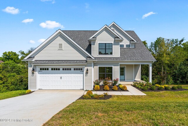 craftsman inspired home featuring a garage, a porch, and a front lawn