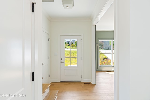 doorway featuring light wood-type flooring and crown molding