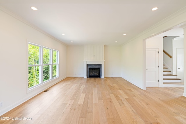 unfurnished living room with crown molding and light wood-type flooring