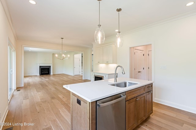 kitchen with dishwasher, crown molding, light hardwood / wood-style flooring, sink, and an island with sink